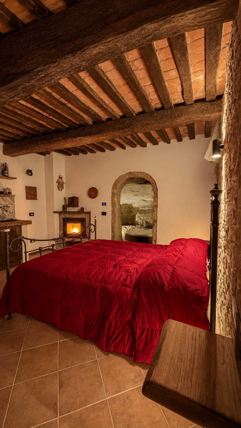 Camera con letto matrimoniale, travi a vista e camino